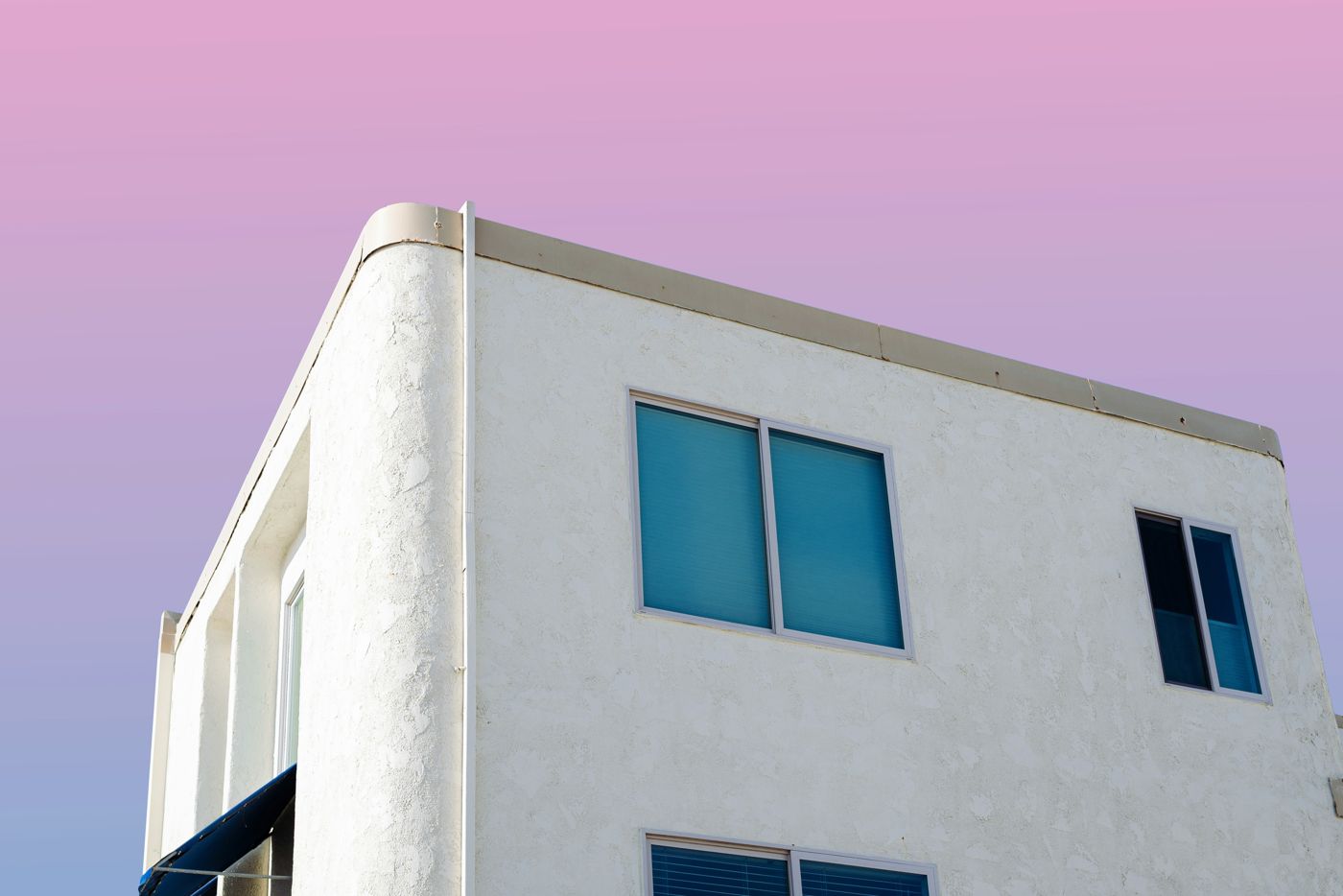 The corner of a white building with blue windows