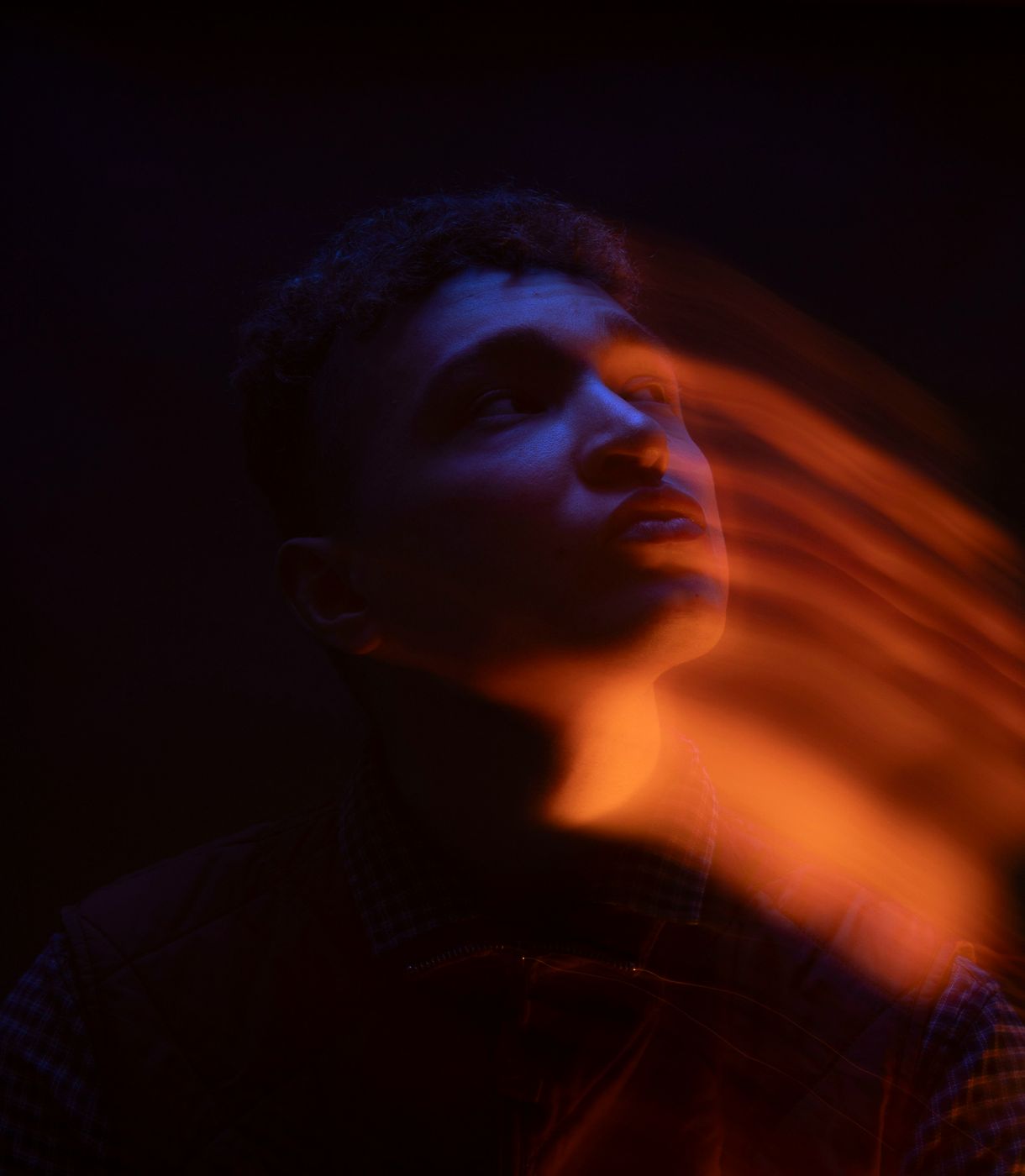 A person silhouetted against orange light